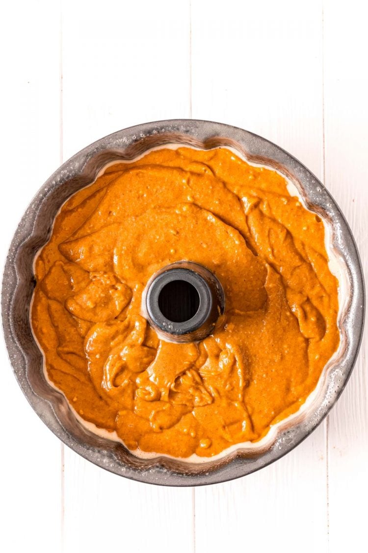 A bundt cake pan filled with pumpkin cake batter ready to bake.