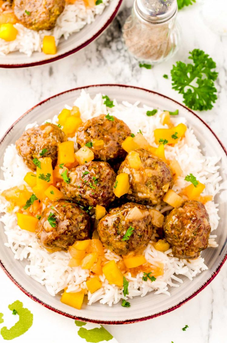 Overhead photo of a plate of white rice topped with sweet and sour meatballs.