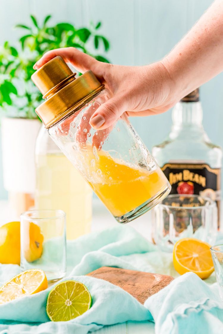 Bourbon sour being shaken in a cocktail shaker.