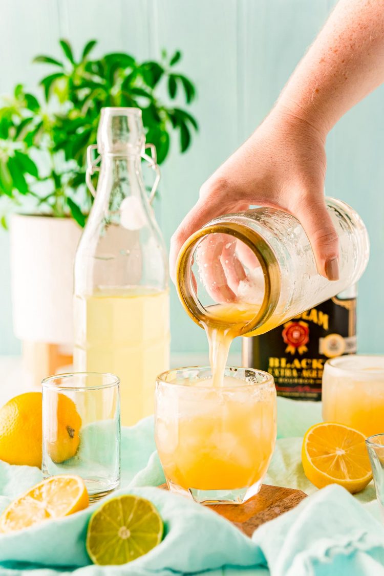 Bourbon sour being poured into a cocktail glass.