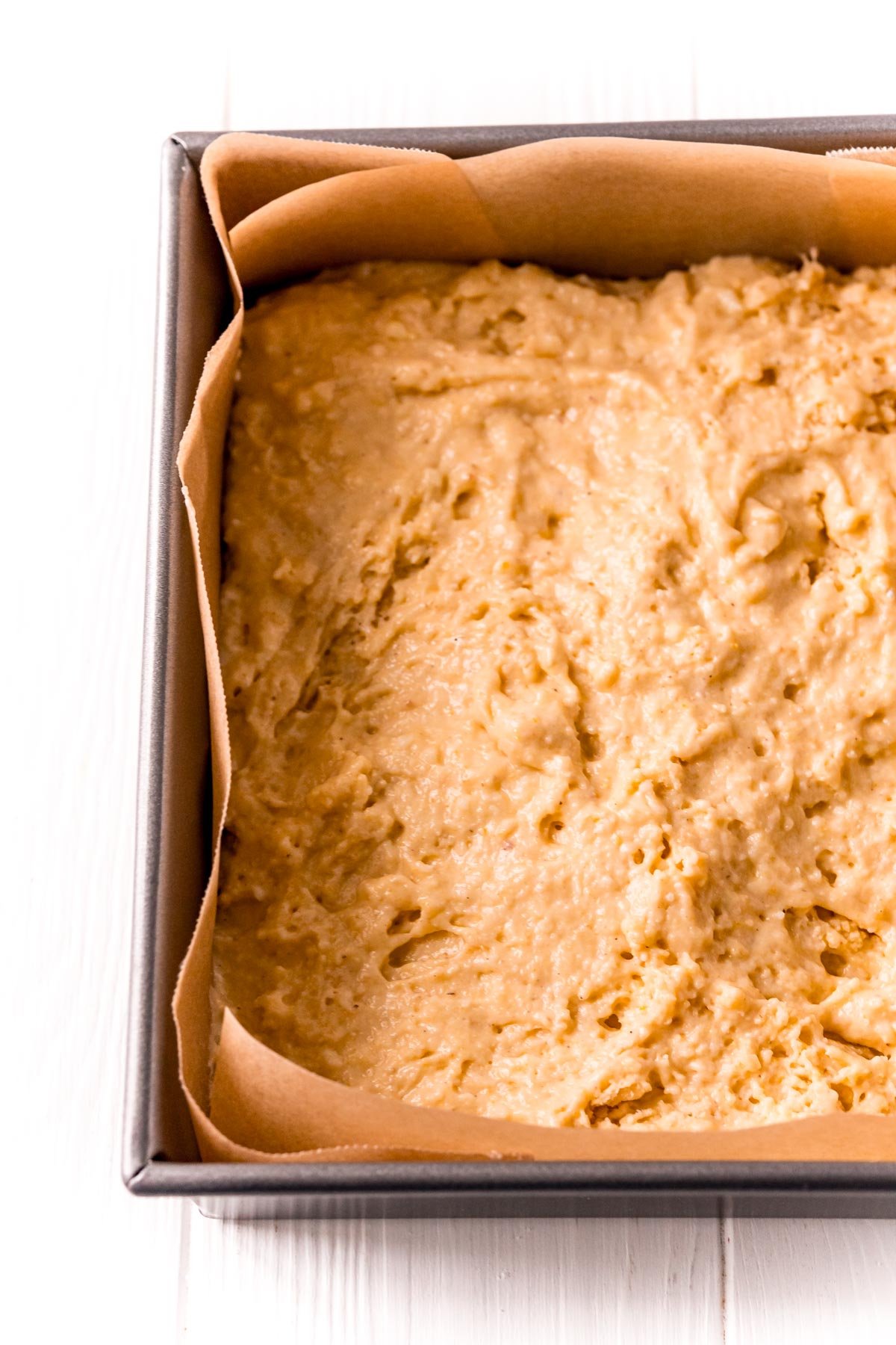 Cornbread batter in a baking pan ready to go in the oven.