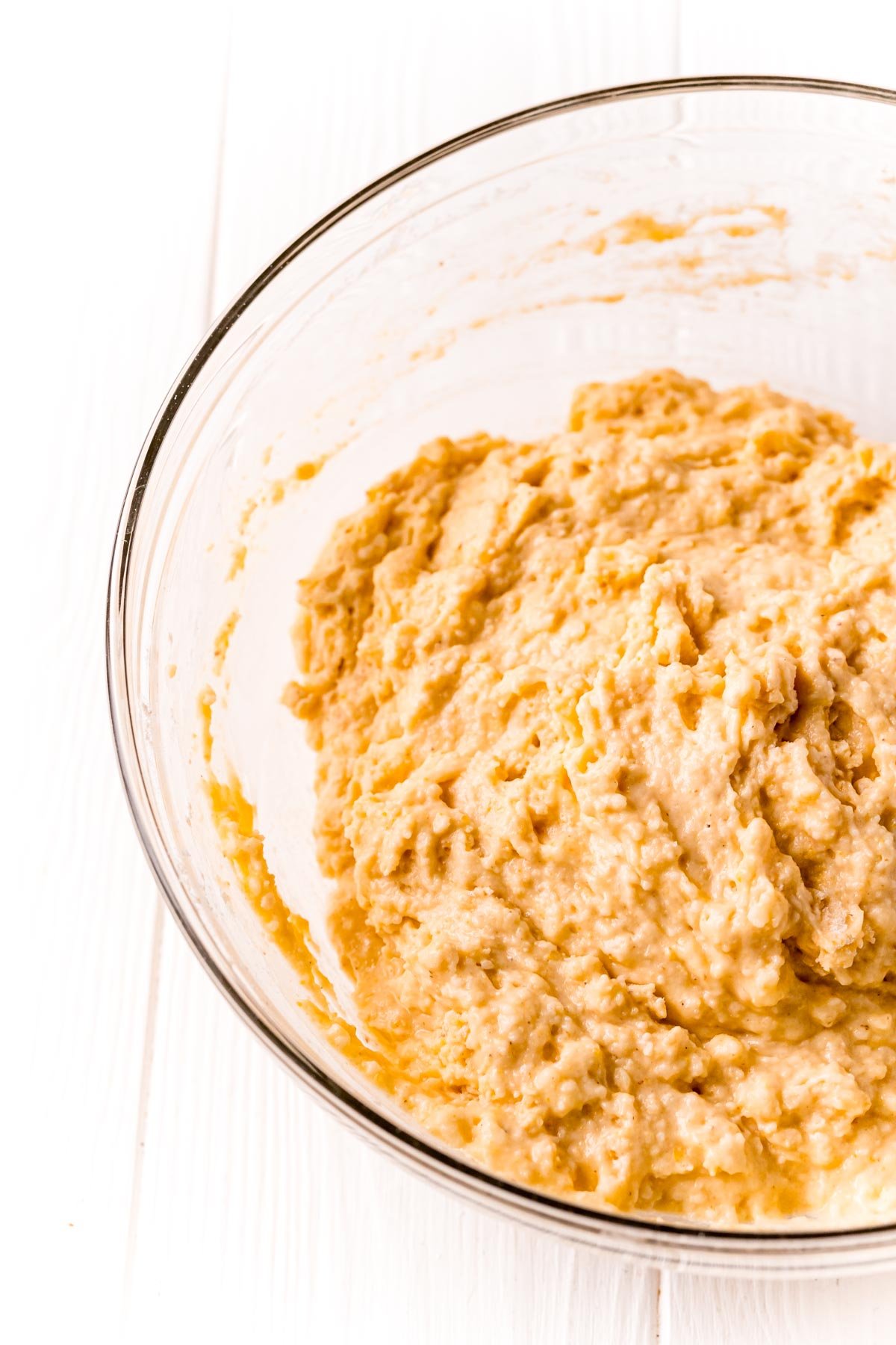 Cornbread batter mixed in a glass mixing bowl.