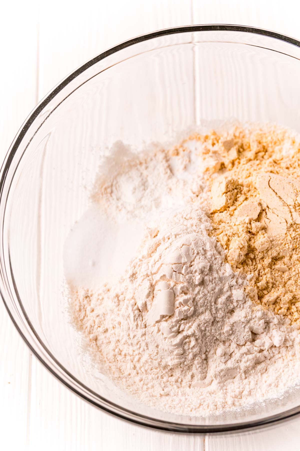 Flour, cornmeal, and sugar in a glass mixing bowl.