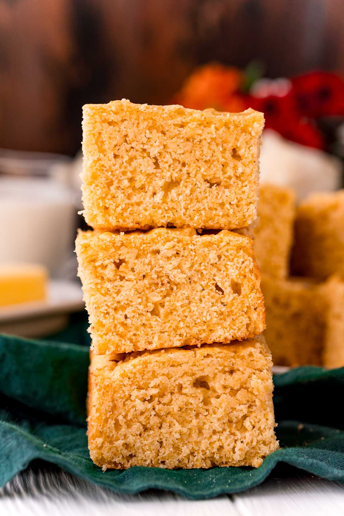 Three slices of cornbread stacked on top of each other on a green napkin.