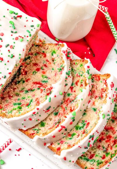 Close up of christmas quick bread sliced on a white serving tray.