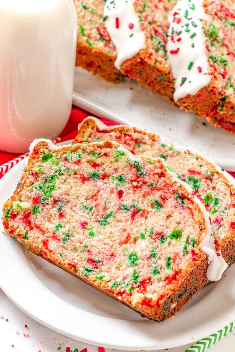 Close up photo of two slices of christmas bread on a white plate.