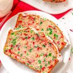 two slices of christmas quick bread on a white plate.