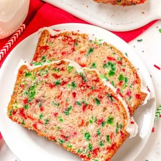 two slices of christmas quick bread on a white plate.