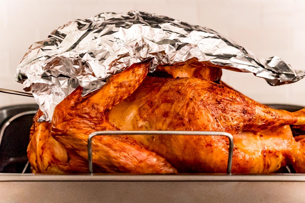 Aluminum foil covering the top portion of a roasted turkey.