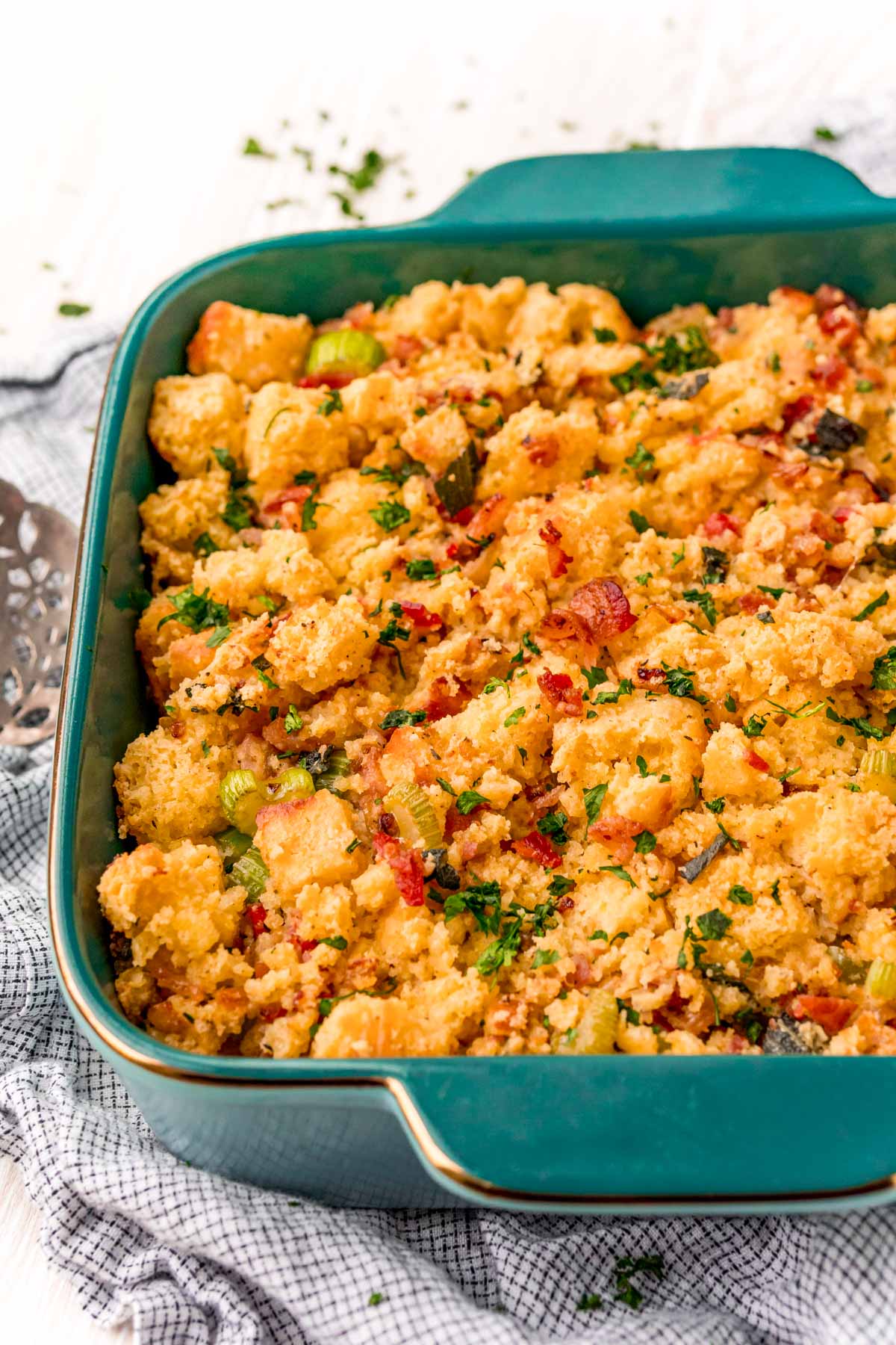 Cornbread dressing in a teal baking dish.