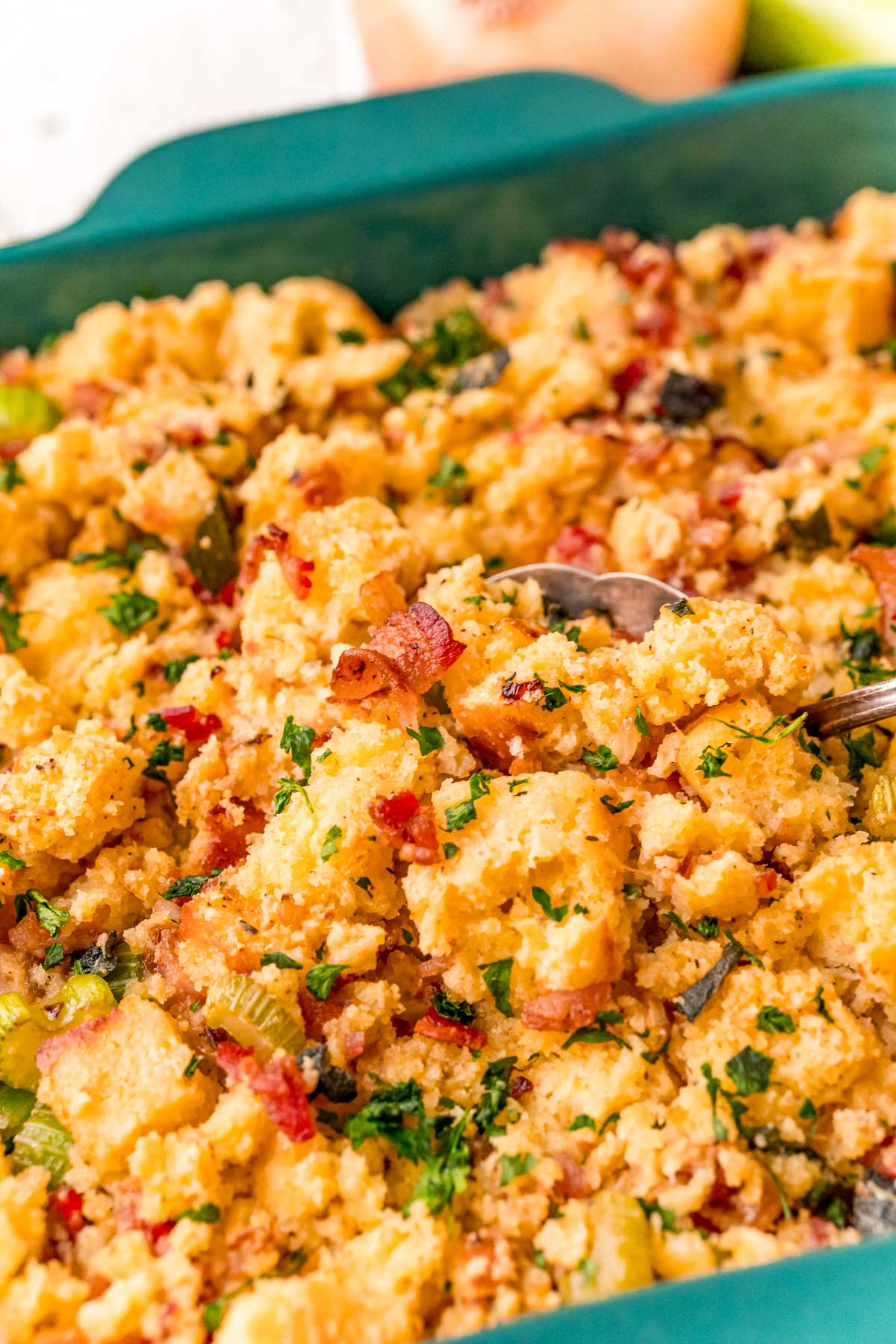 Close up photo of cornbread stuffing getting scooped out of a dish.