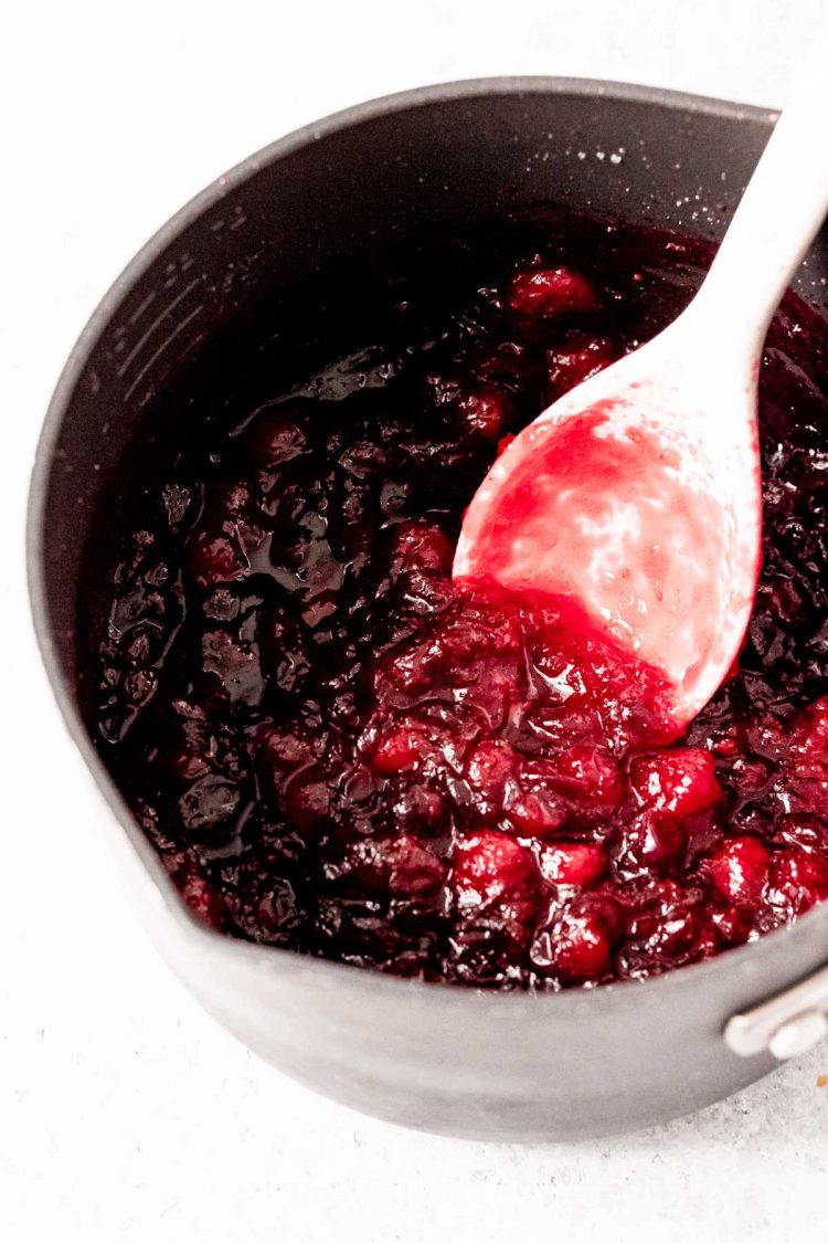 Cranberries being cooked in a medium saucepan.