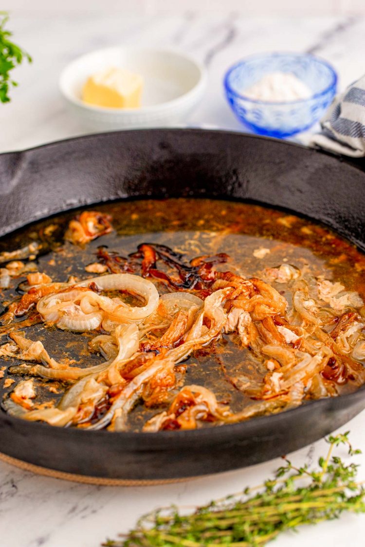 Close up photo of caramelized onions in a cast iron pan.