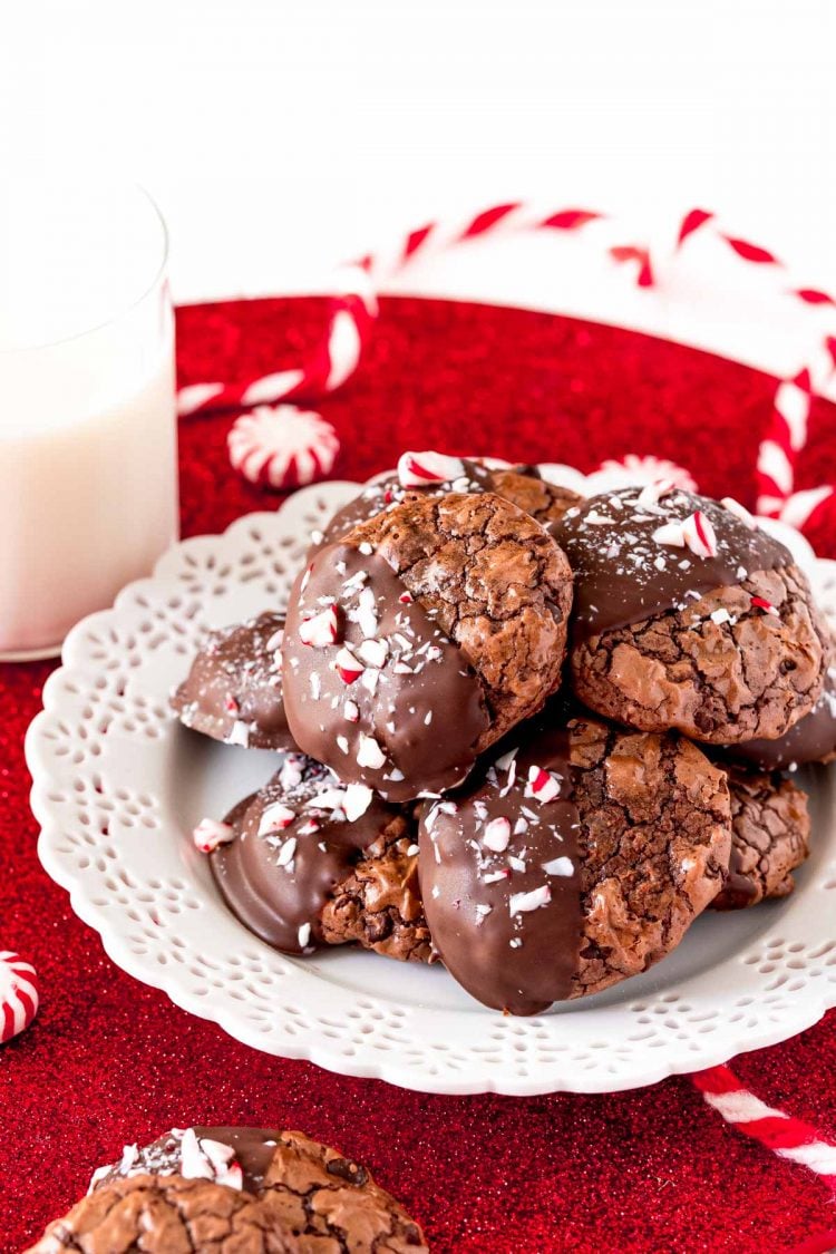 Peppermint chocolate cookies on a white plate with a glass of milk next to it.