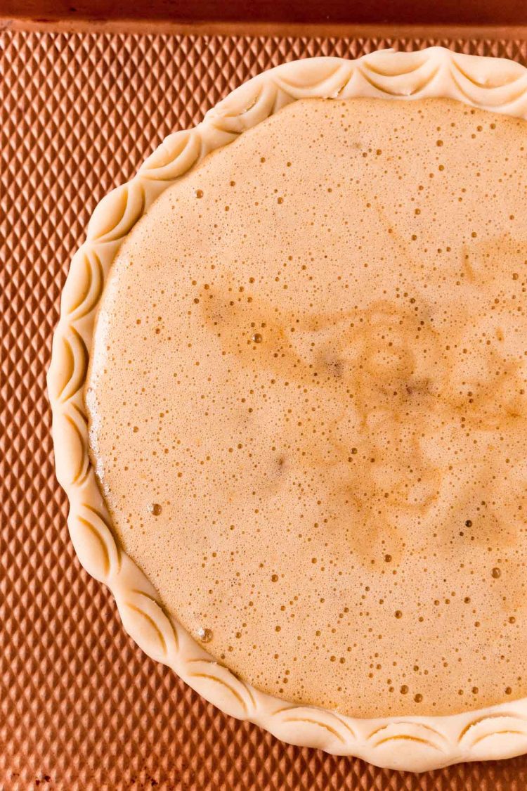 Uncooked walnut pie on a bronze cookie sheet ready to bake.