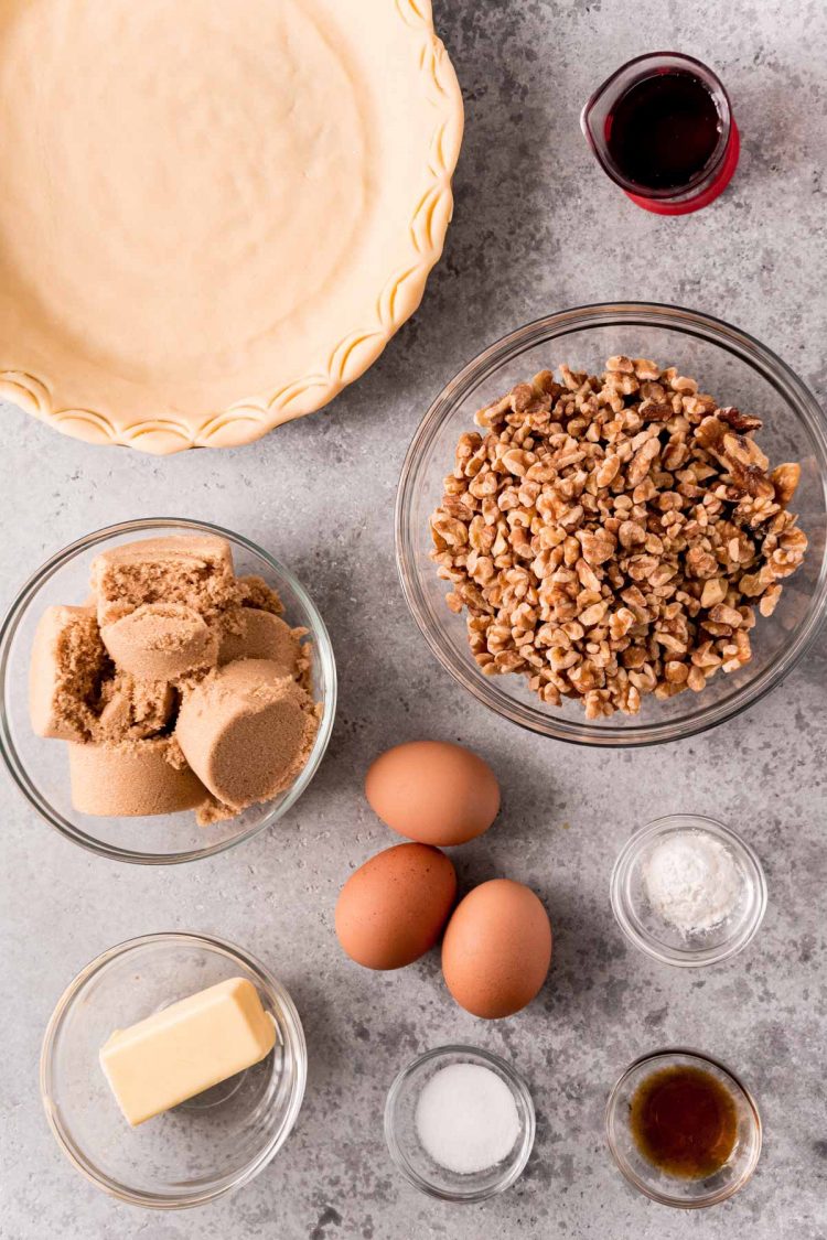 Overhead photo of ingredients to make a walnut pie on a gray countertop.