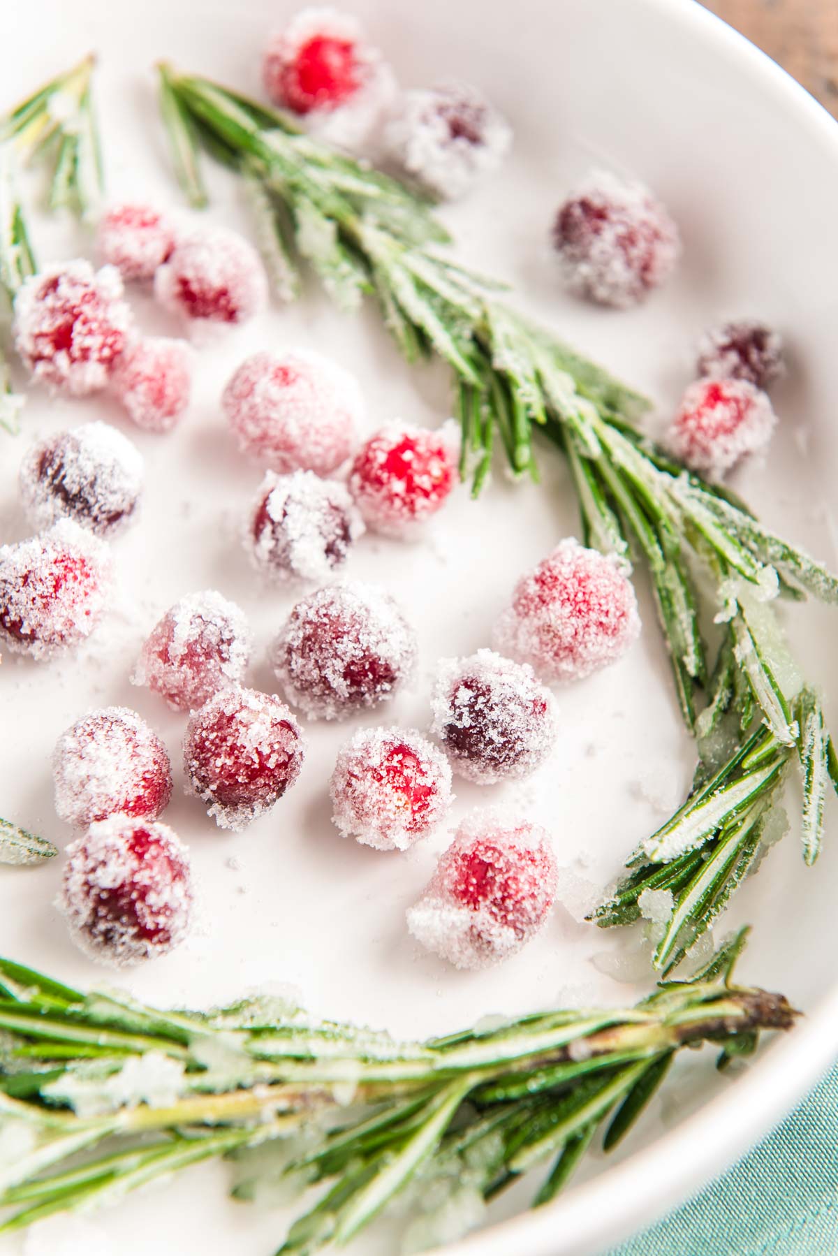 Cranberries and rosemary dipping in simple syrup and sugar.