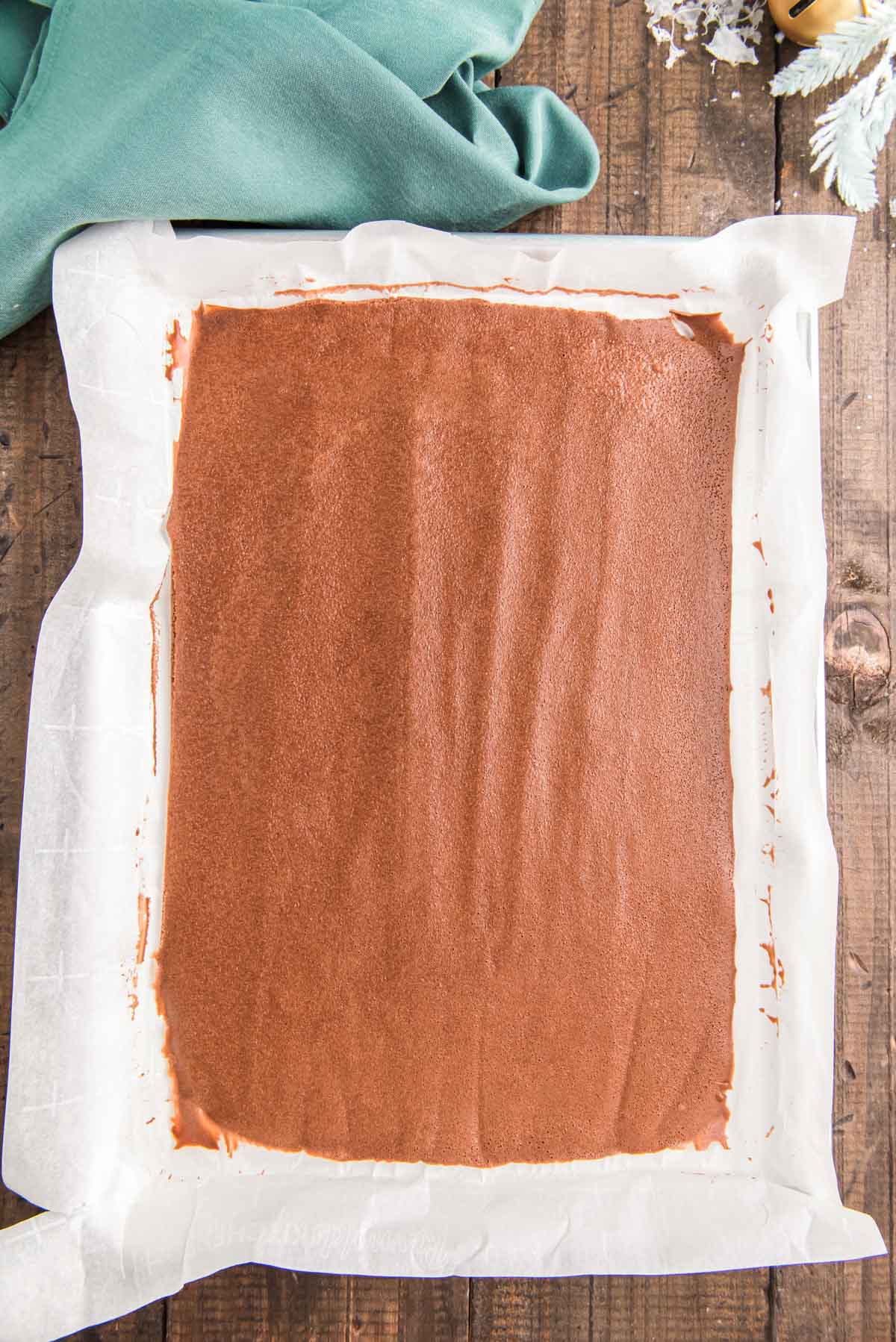 Chocolate sponge cake cooking in a jelly roll pan.