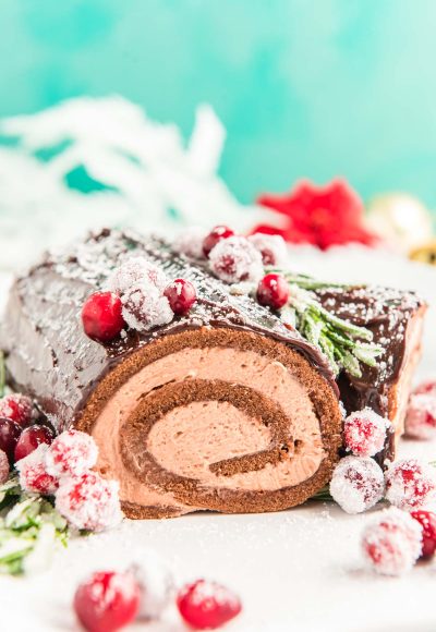 Close up photo of a buche de noel on a white plate.