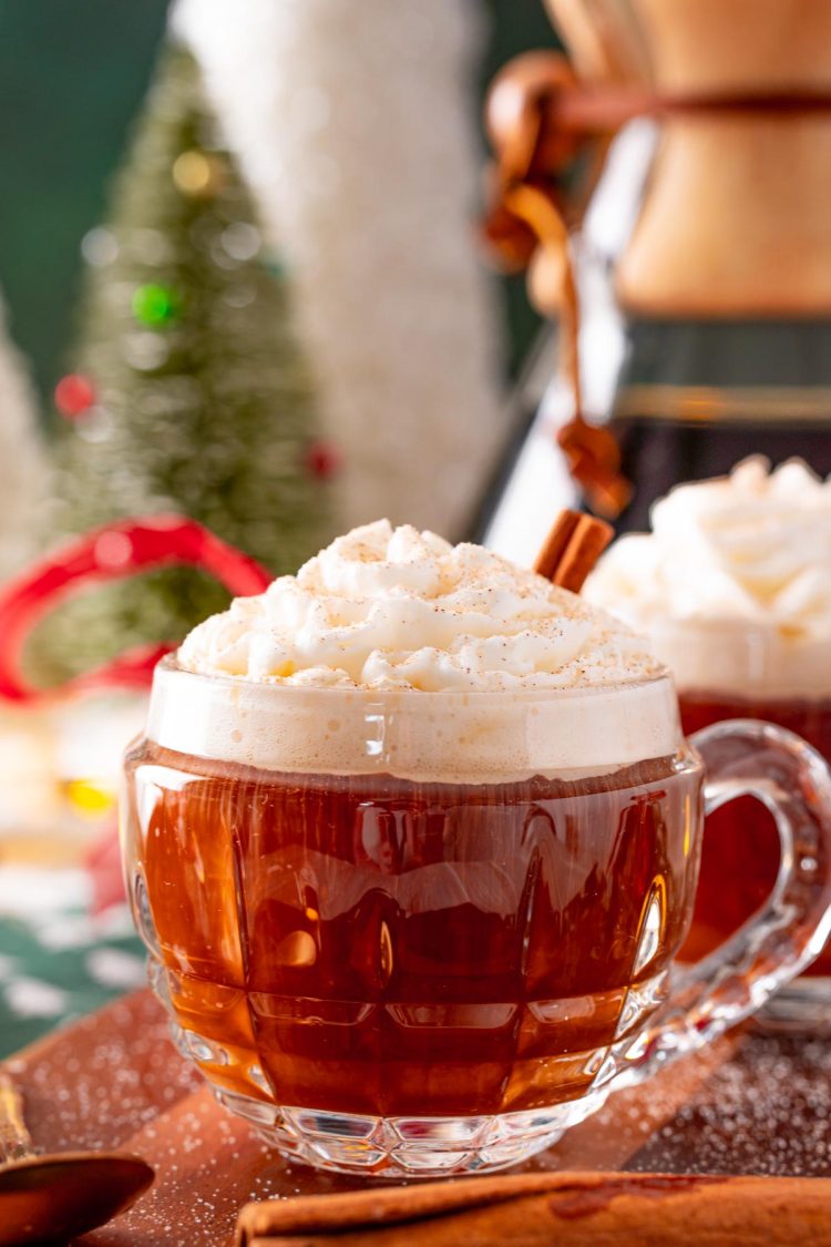 Close up photo of a mug of hot coffee topped with whipped cream at christmastime.