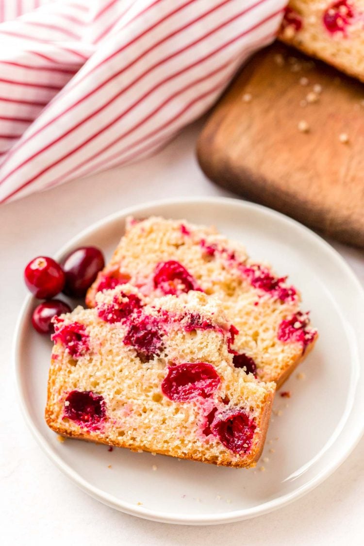 Two slices of cranberry quick bread on a white plate.