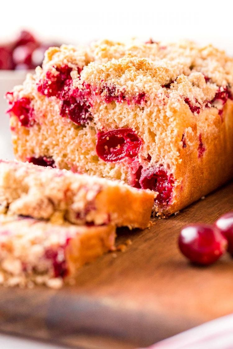 Close up photo of cranberry bread that has been sliced halfway through.