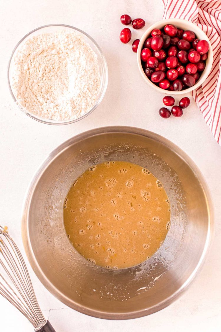 Overhead photo of a metal mixing bowl with sugar and egg beaten together.