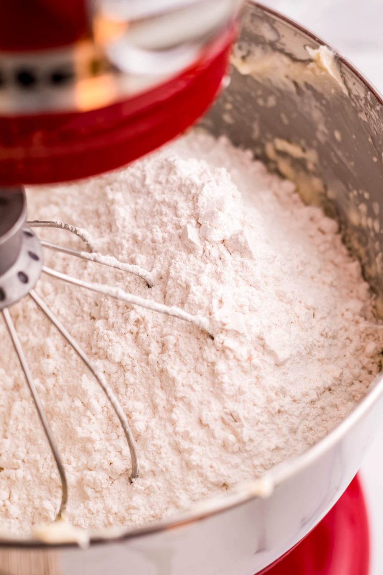 Dry ingredients added to a stand mixer making cake batter.