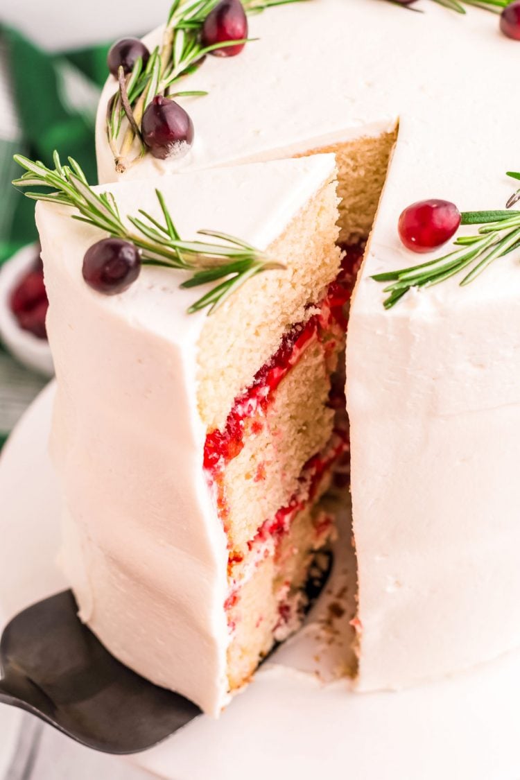 A slice of white chocolate cake being removed from the cake on a cake server.