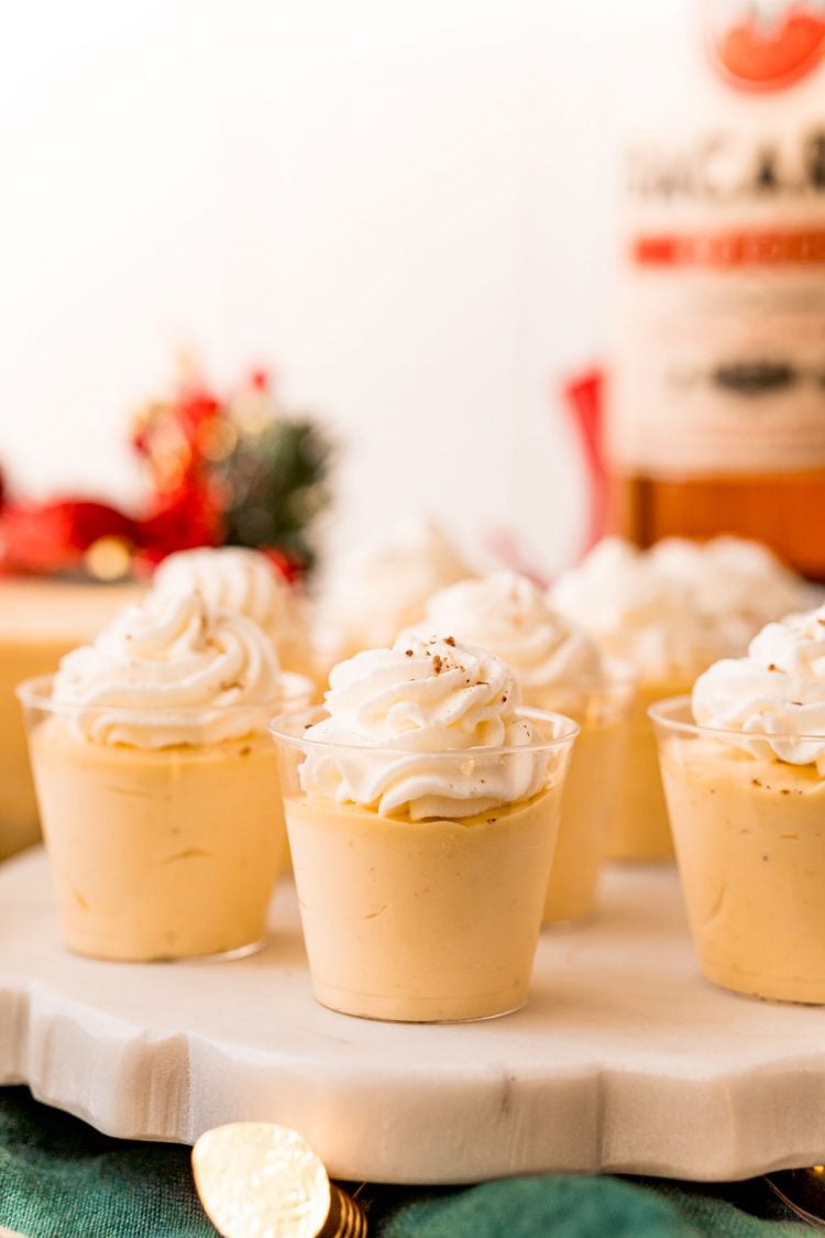 Close up photo of eggnog pudding shots on a white marble stand.