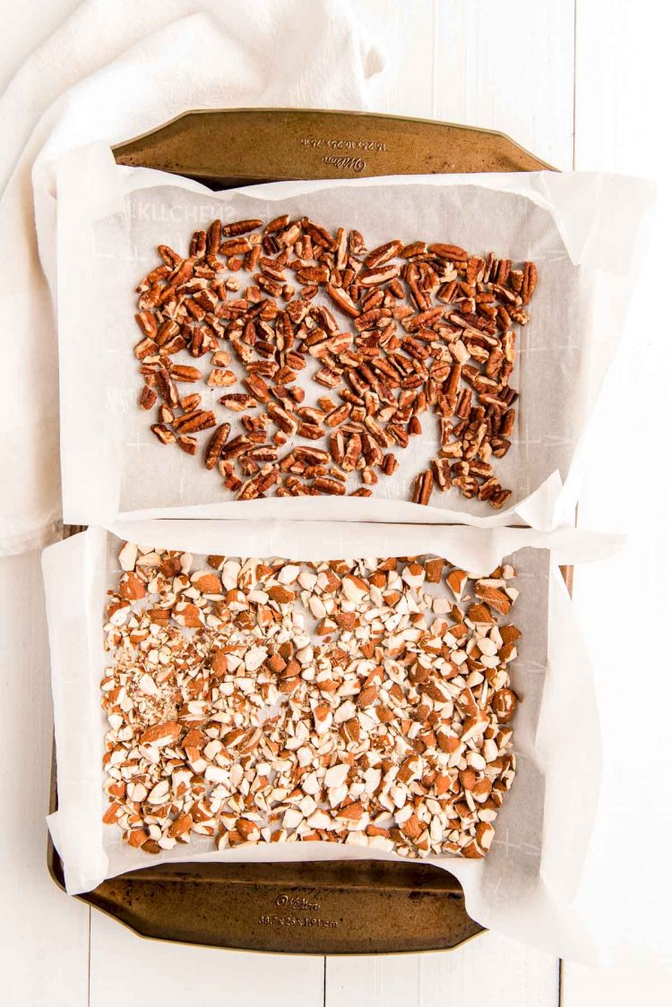 Overhead photo of a baking sheet with nuts on parchment paper for toasting.