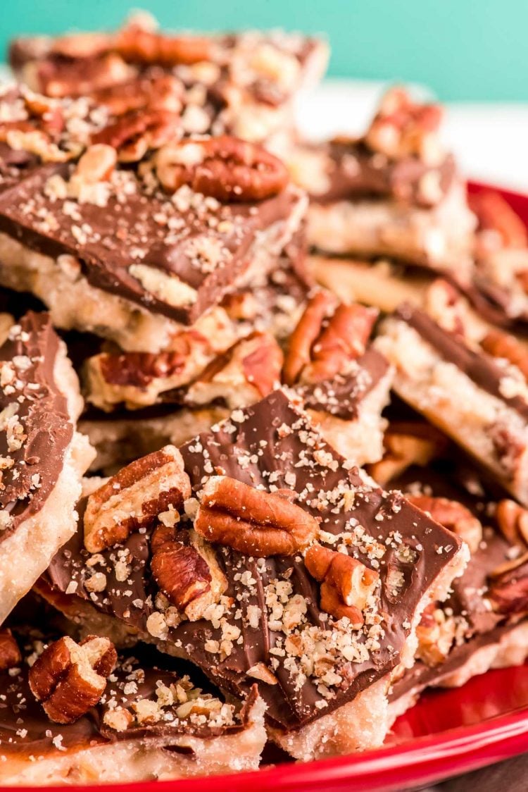 Close up photo of a pile of english butter toffee on a red plate.