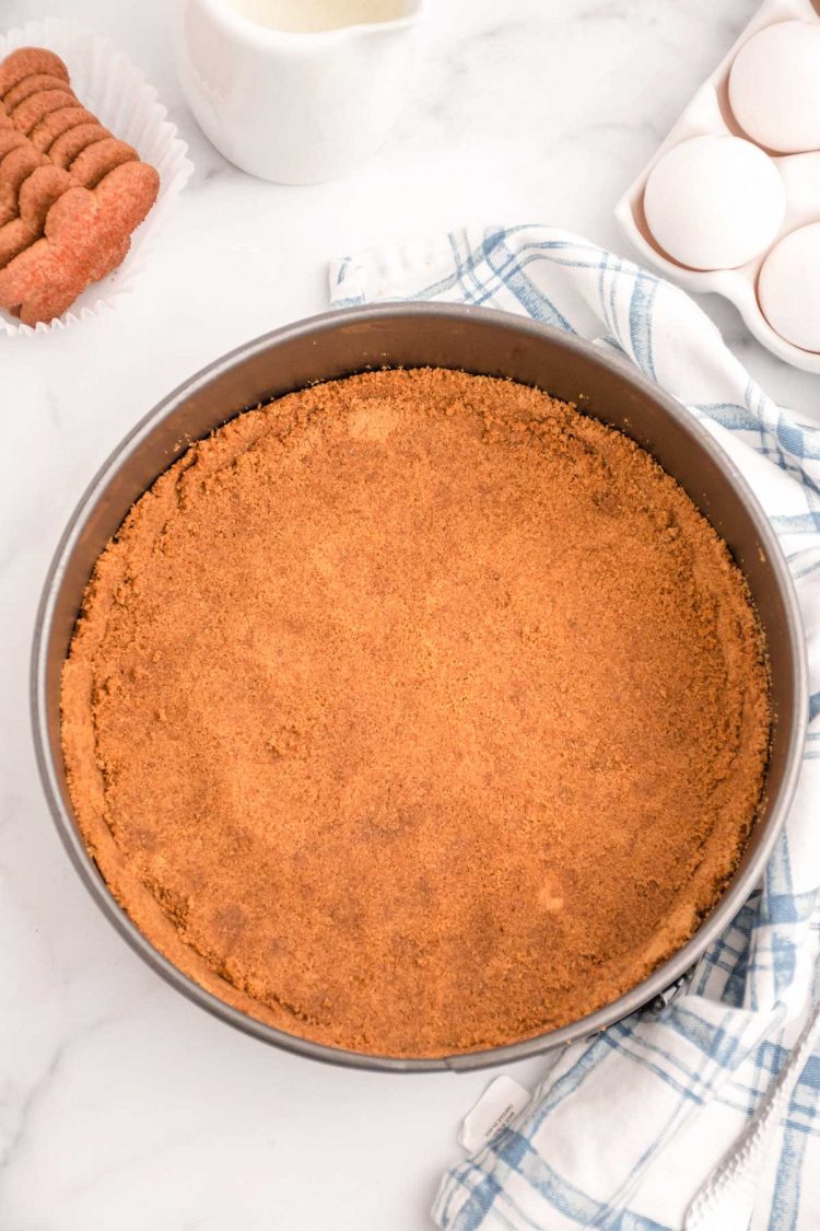 Overhead photo of a gingersnap cookie crust in a springform pan.