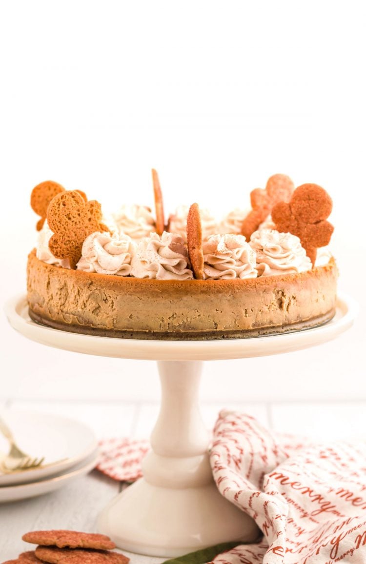 A gingerbread cheesecake on a white cake stand.