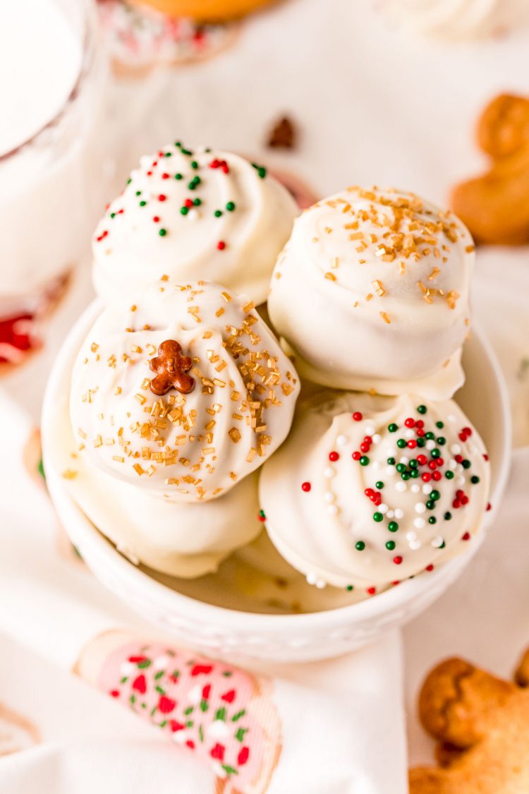 Close up photo of white chocolate dipped gingerbread balls in a white mug.