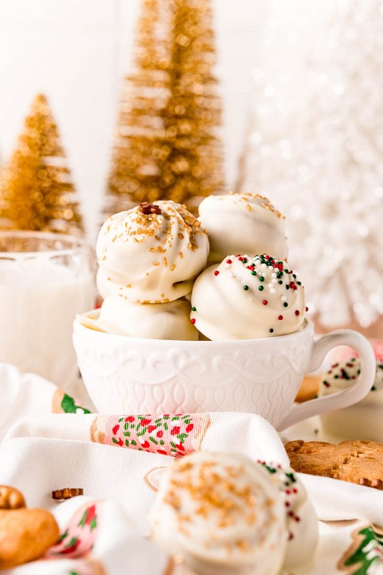 White chocolate covered gingerbread truffles in a white mug.