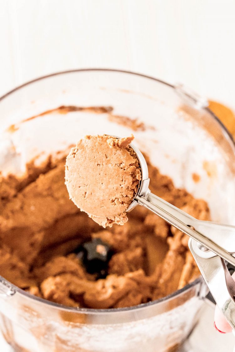 Gingerbread balls mixture being scooped with a cookie scoop.