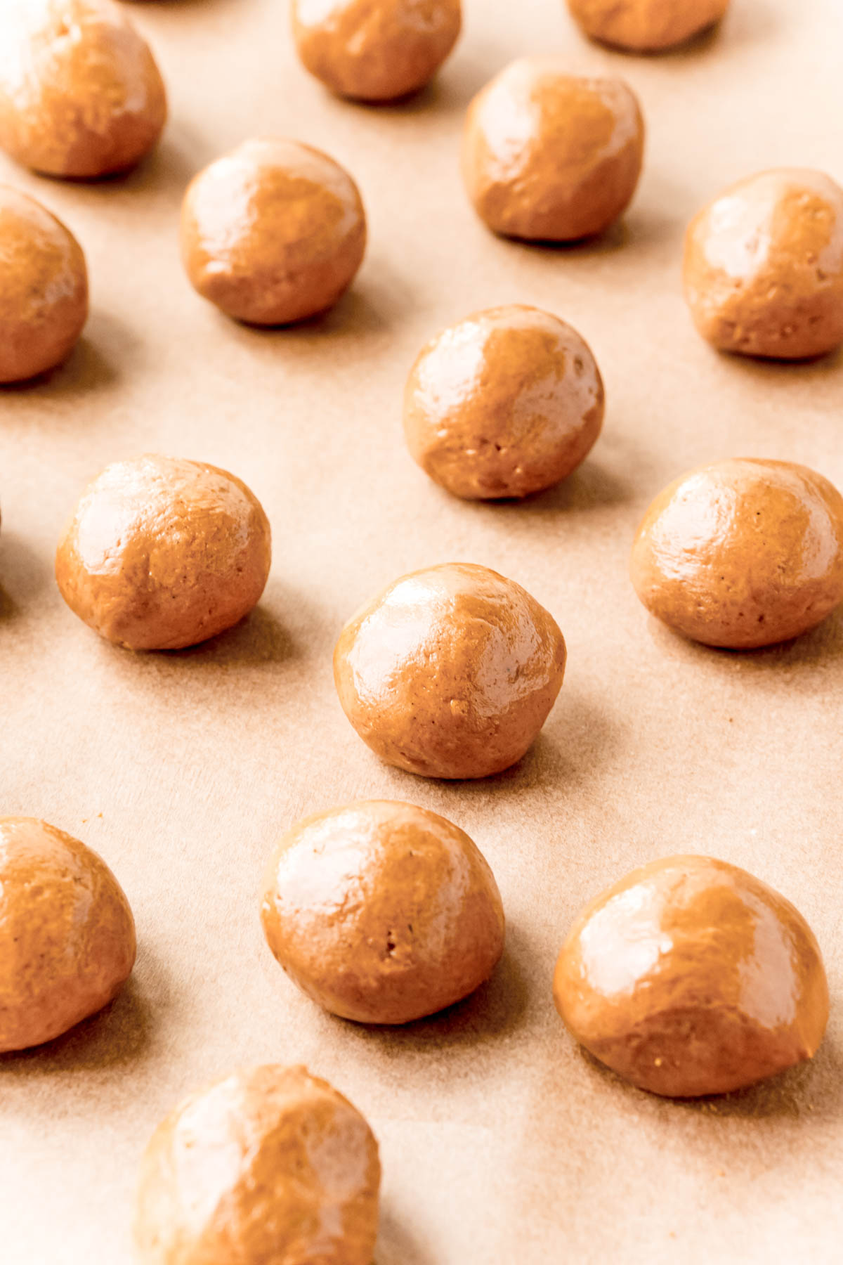 Gingerbread truffles on a parchment lined baking sheet ready to chill.