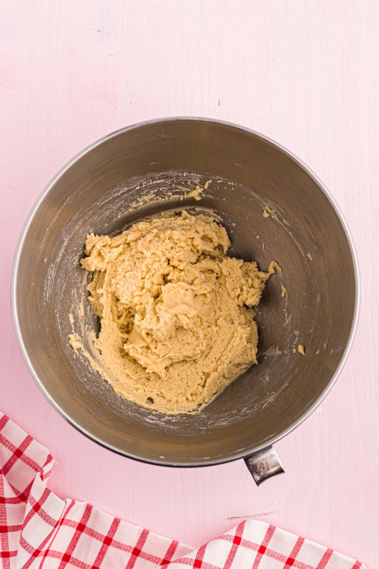 Cookie dough in a metal mixing bowl.