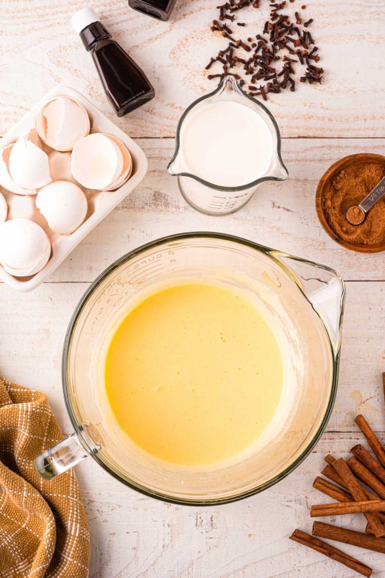 Eggs and sugar whisked together in a large glass pitcher.