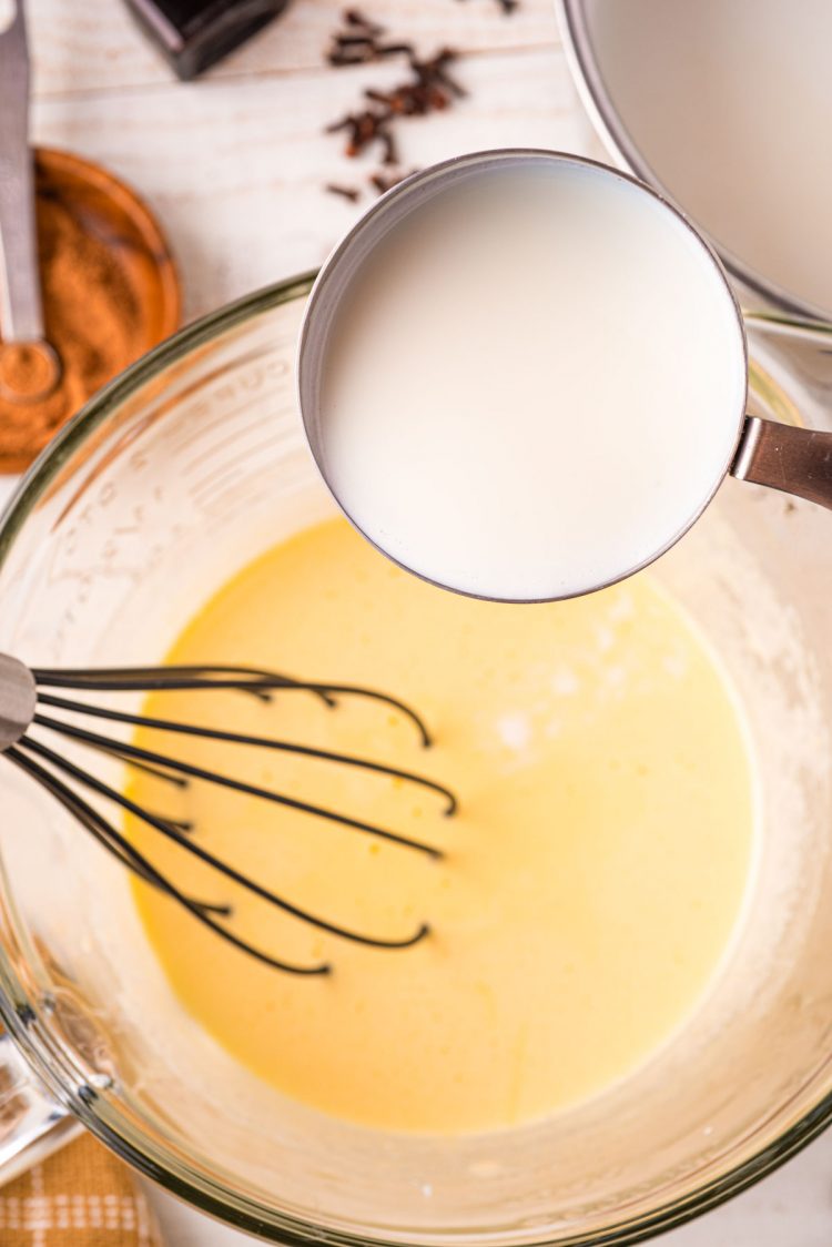 Warm cream being added to a sugar and egg mixture to temper.