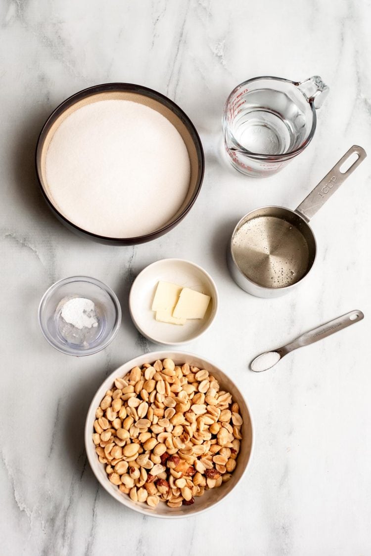 Overhead photo of ingredients to make peanut brittle on a marble surface.