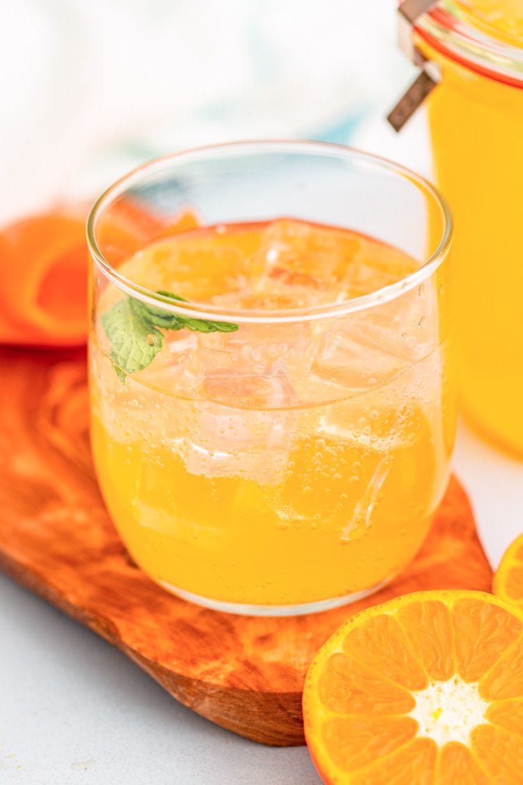 A glass with ice and orange simple syrup.