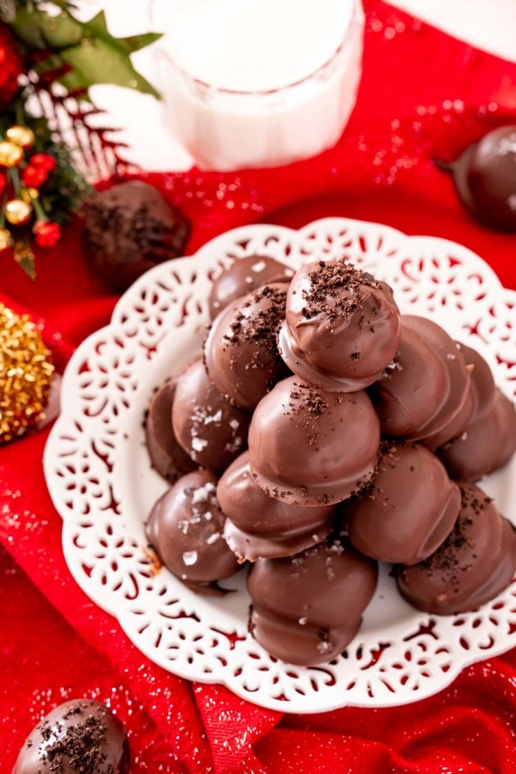 Oreo truffles on a white plate on a red napkin.