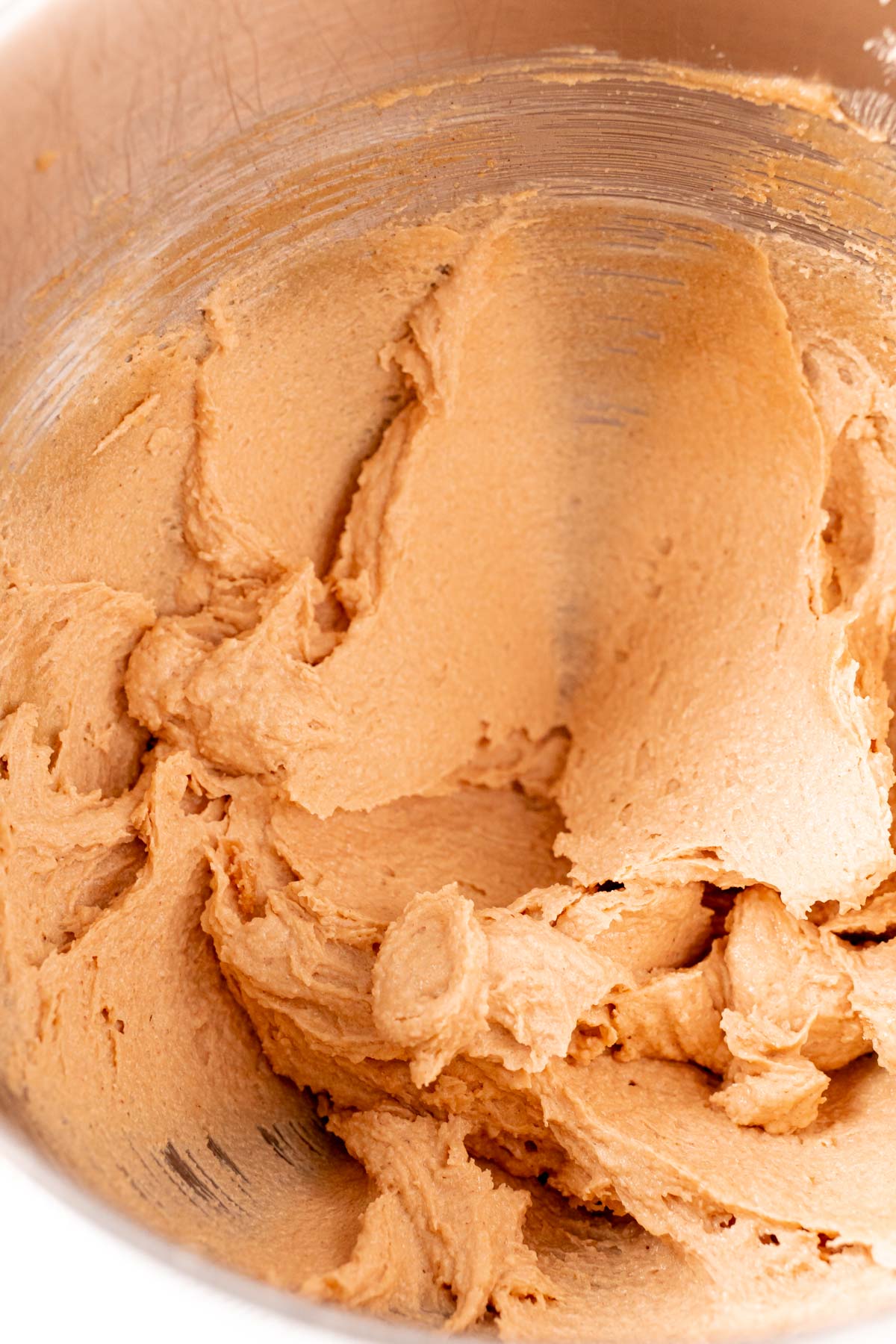 Peanut butter cookie dough in a metal mixing bowl.