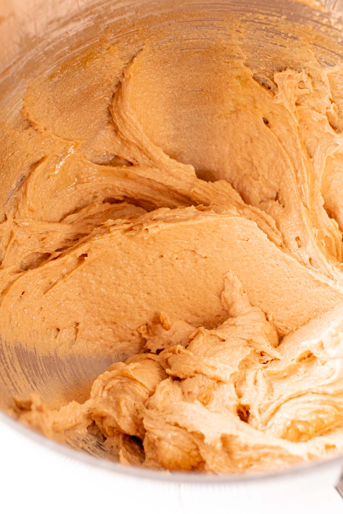 Peanut butter cookie dough in a metal mixing bowl.