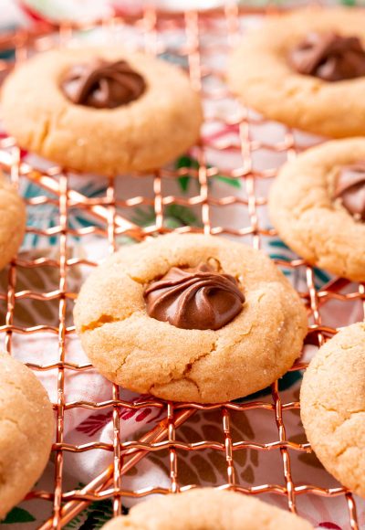 Close up photo of peanut butter blossoms on a copper wire rack.