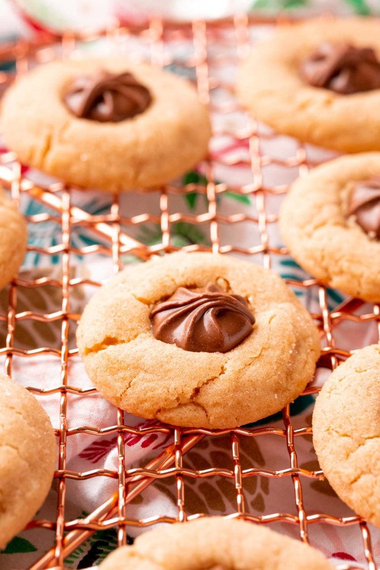 Close up photo of peanut butter blossoms on a copper wire rack.