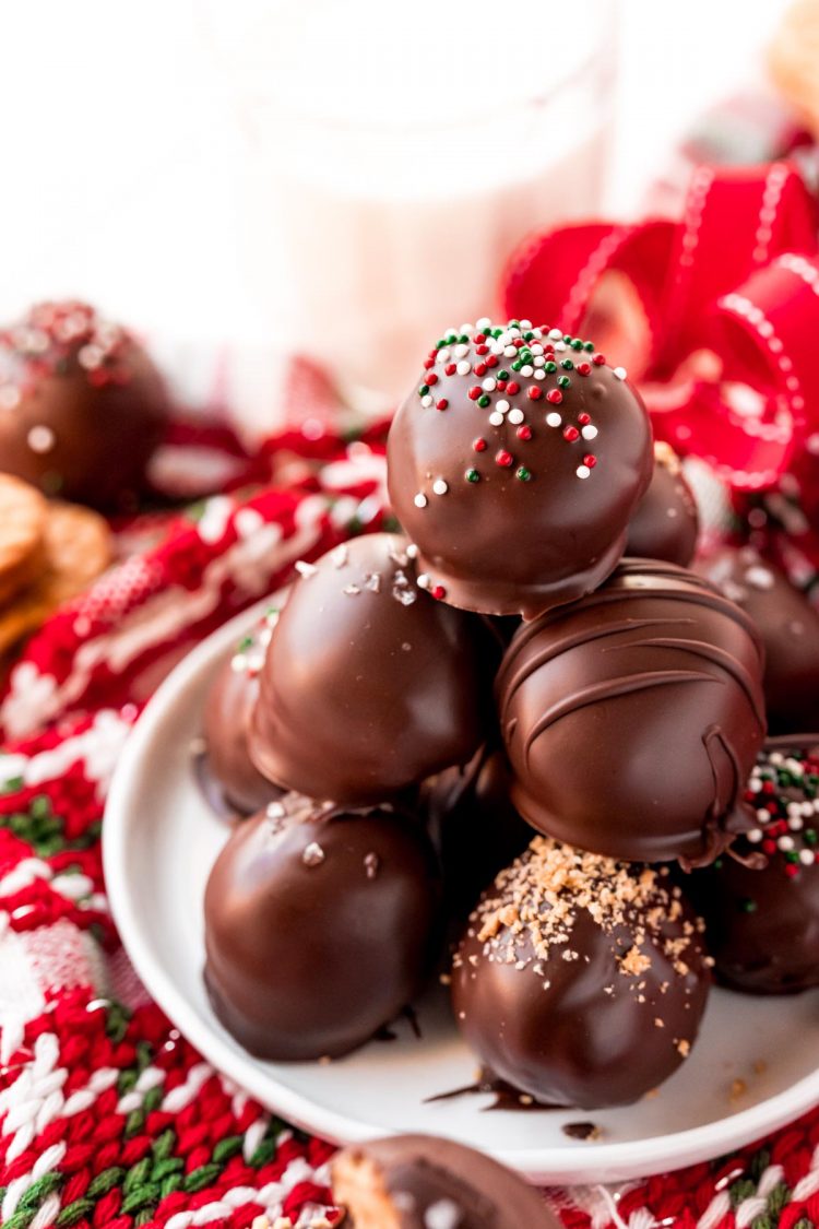 Close up photo of a stack of peanut butter balls on a white plate.