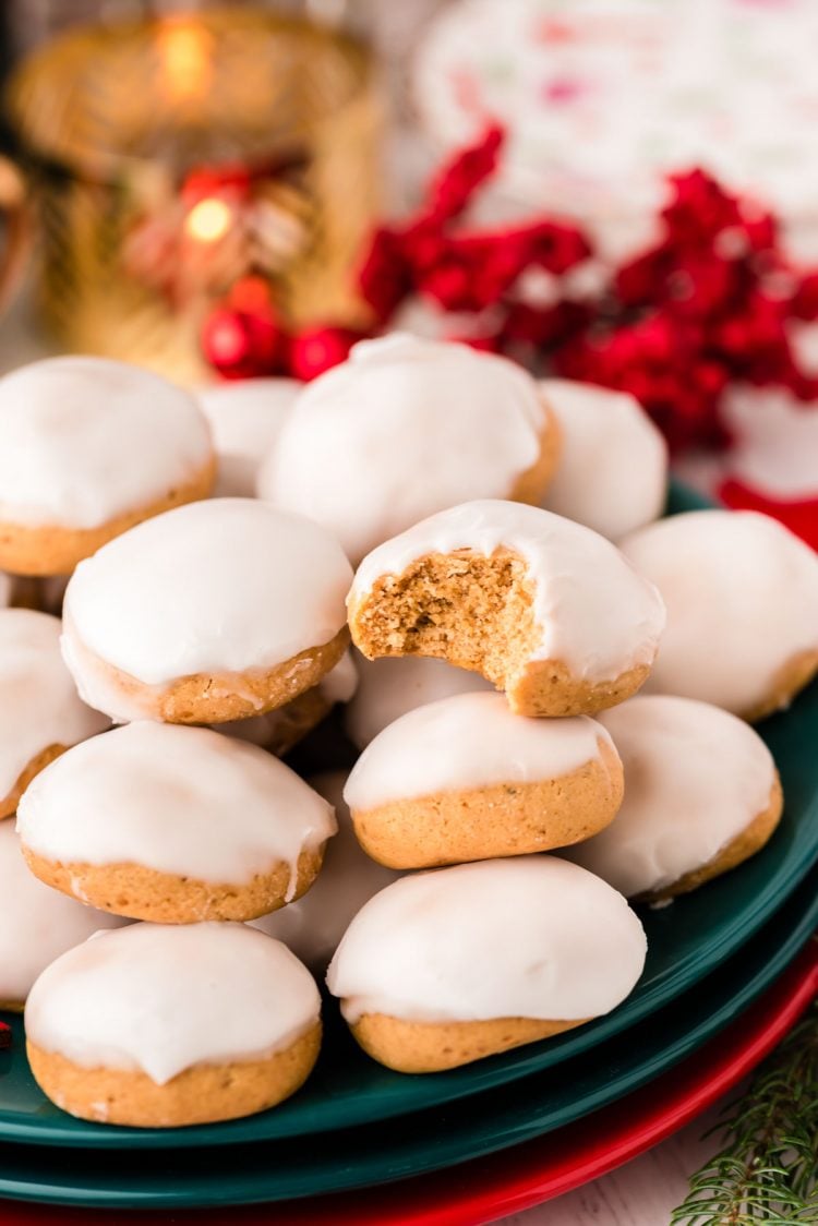 A plate of pfeffernusse german spice cookies with one missing a bite.